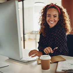 Woman smiling while sitting at desk in office