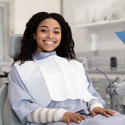 Woman smiling while sitting in treatment chair