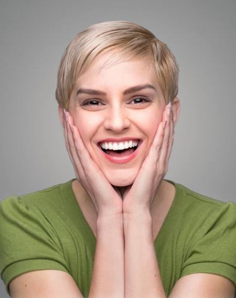Woman in green showing off new smile with dental bonding in Garland