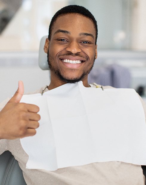 A man giving a thumbs up at the dentist