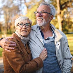 Older couple enjoying the benefits of dental implants in Garland